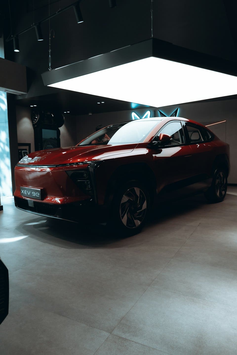 Un elegante coche eléctrico conceptual rojo está en un piso de exposición.